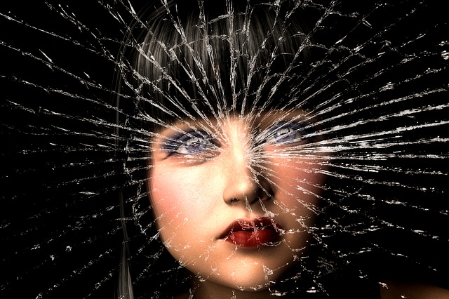 Frauenportrait hinter einer gesplitterten Glasscheibe